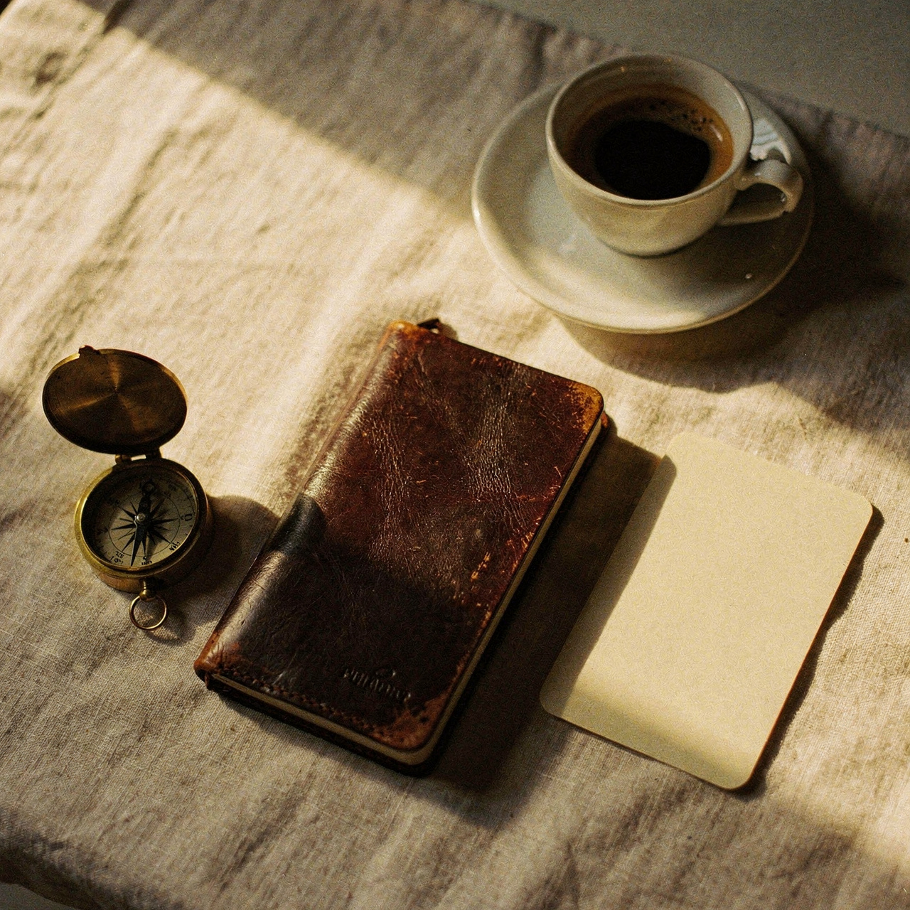 Warm moody flatlay of a security analyst desk with a leather notebook and a single reference card